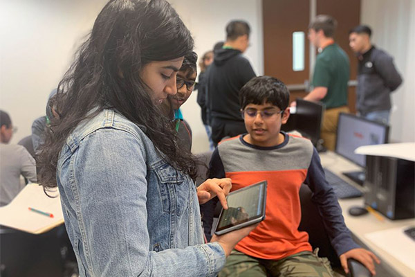 middle school boys and girls working together at the ITS Academy Hackathon at the Jindal School of Management, UT Dallas