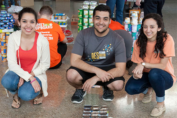 three jindal school students participating in canned food drive