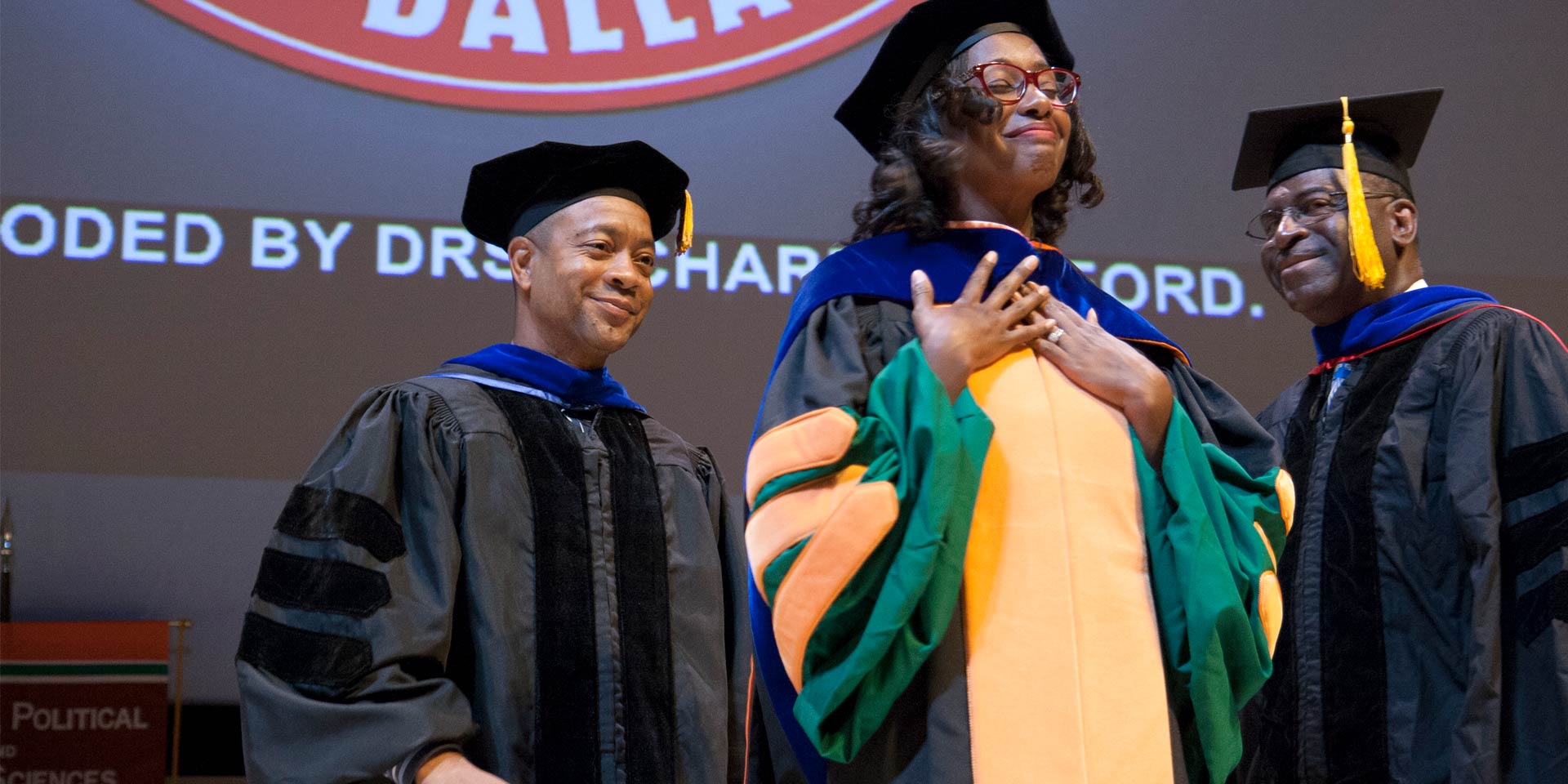 Dr. Carliss Miller PhD’16 is hooded by Dr. Orlando Richard, associate professor of organizations, and Dr. David Ford Jr., professor of organizations, strategy and international management.