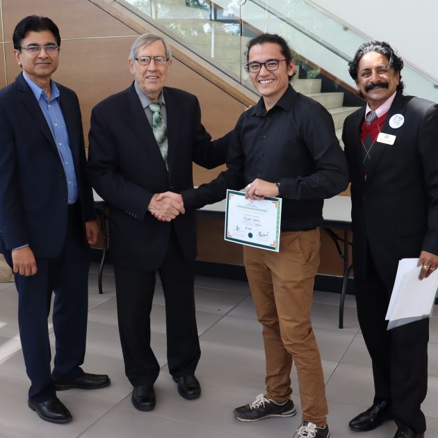 Photo of Ryan Kunz receiving first prize for the poster presentation from Don Huisingh. Ramesh Subramoniam (left) and Kannan Srikanth (right) also pictured.