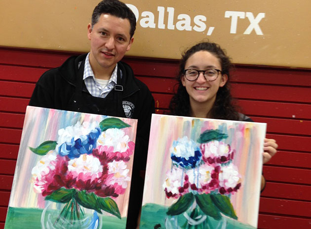 Frank Martinez and his daughter, Maisey, hold up paintings of flowers.