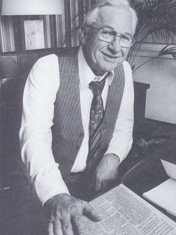 Morris Hite in his office with newspaper