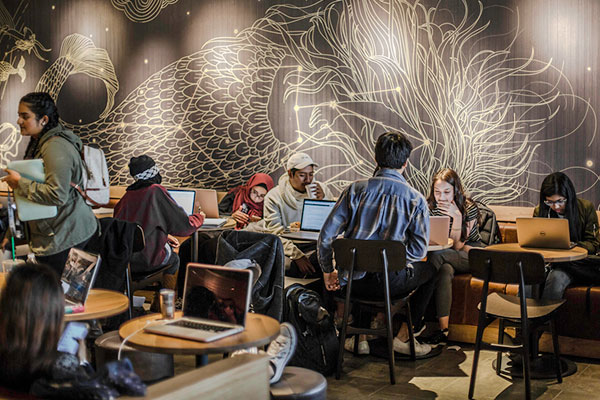 UT Dallas Jindal School students in a campus coffee shop requestion information