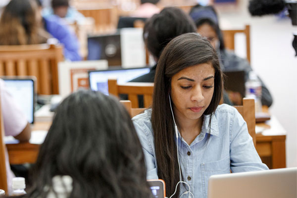 UT Dallas Jindal School student working on her laptop