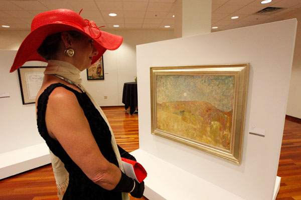 visitor looking at a painting from the Jindal School art collection