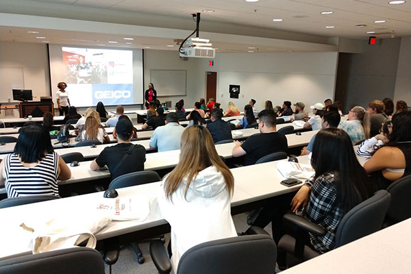 UT Dallas students at a packed class visit by GEICO representatives
