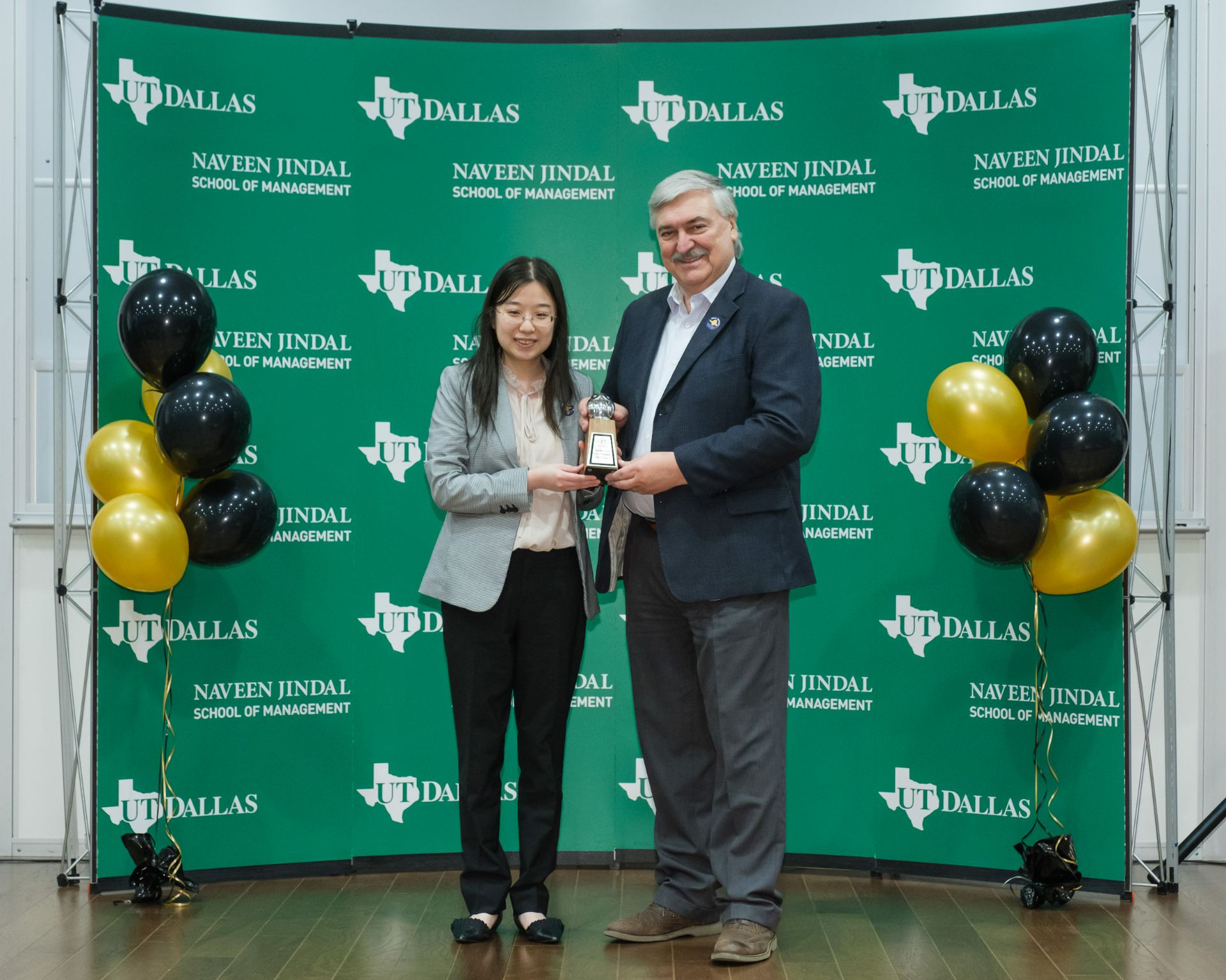 Dr. Zixuan “Maggie” Meng accepts 2023 Owlie Award for Jindal Faculty of the Year from Dean Pirkul.