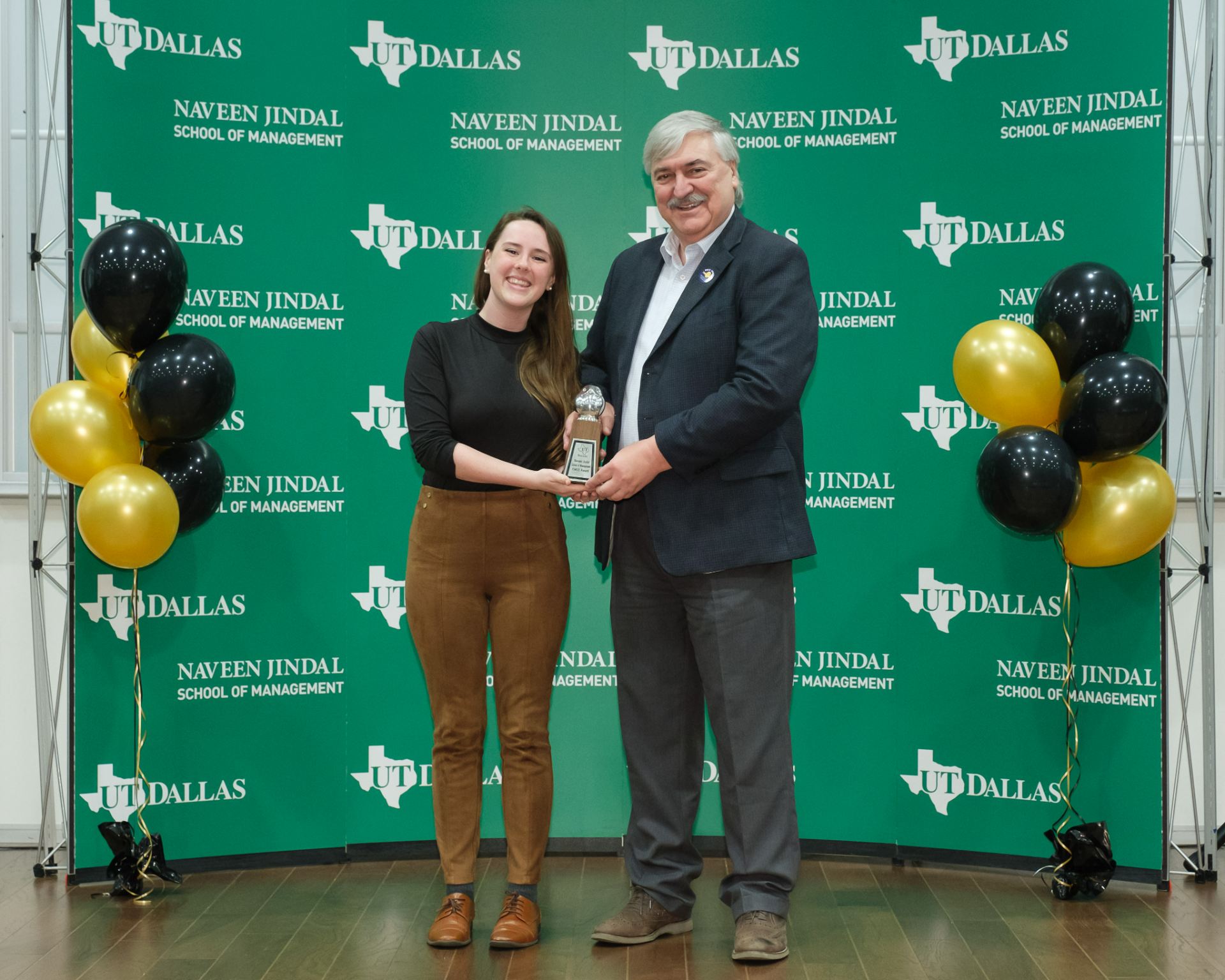 JSOM student Sarah Gifford accepts the 2023 Owlie Award for Undergrad Student Mentor from Dean Hasan Pirkul.