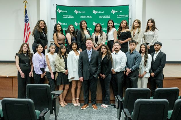 Billy Schewee, director of the Jindal Young Scholars Program at the Naveen Jindal School of Managements, standing with the 19 members of the 2023 cohort.