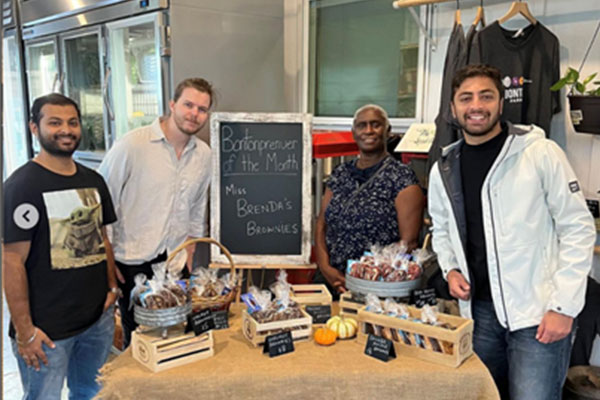 UT Dallas students stand at a table with a chalkboard sign that reads, ‘Bontonpreneur of the Month. Miss Brenda’s Brownies,