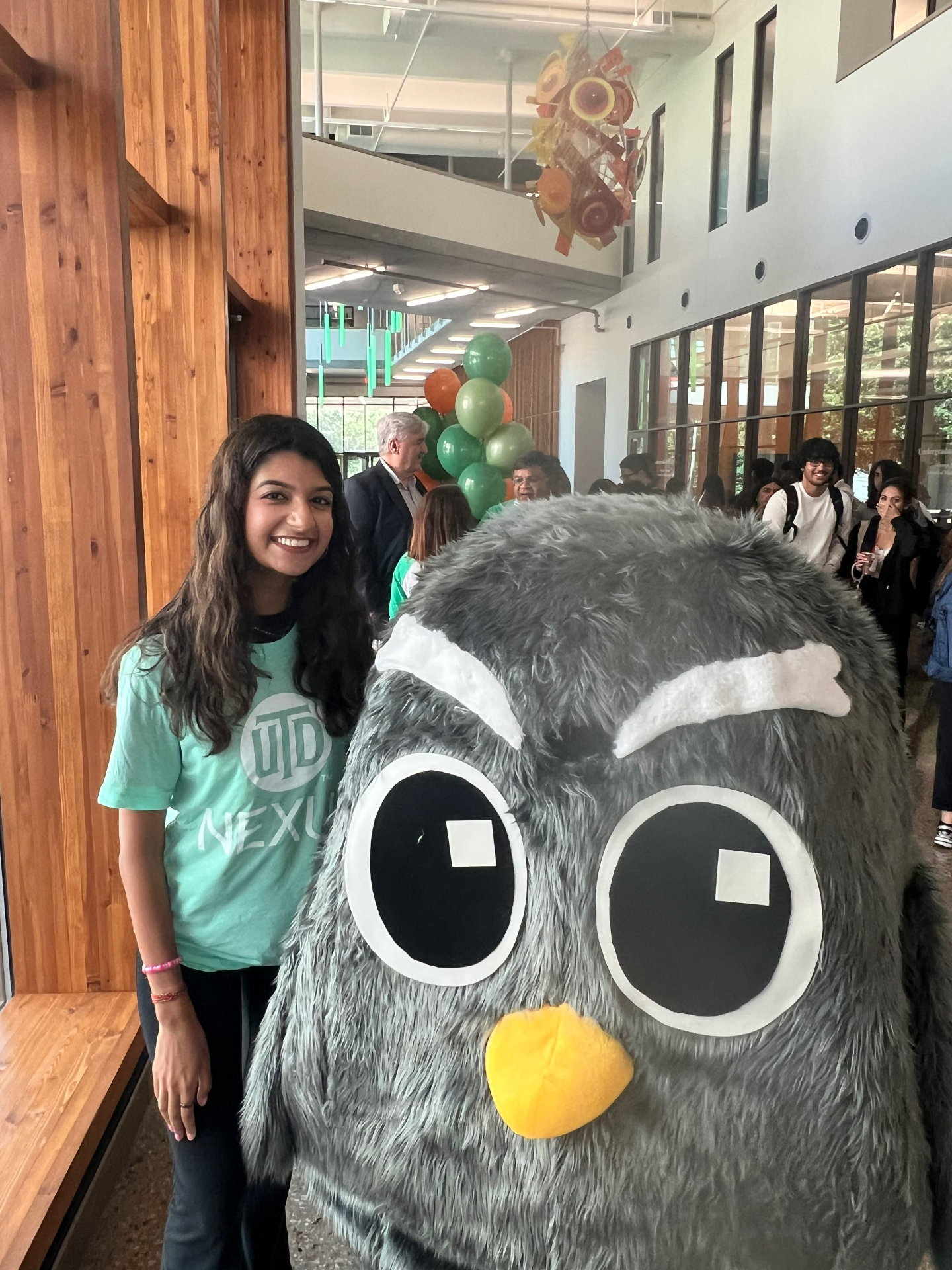 A student poses with Owlie the JSOM unofficial mascot.