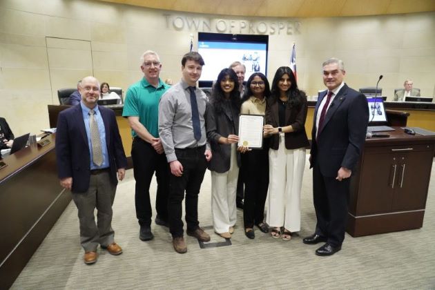 Photo of JSOM students and faculty with Leigh Johnson, left, and Mayor David Bristol (right), who read a proclamation at the Prosper town hall meeting recognizing Jindal School students for their efforts.