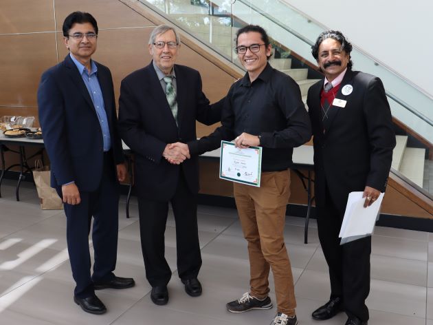 Photo of Ryan Kunz receiving first prize for the poster presentation from Don Huisingh. Ramesh Subramoniam (left) and Kannan Srikanth (right) also pictured.