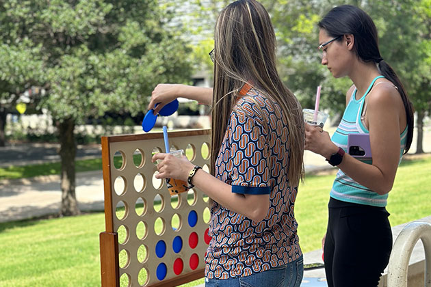 Students play Connect 4 outside JSOM before exam week.